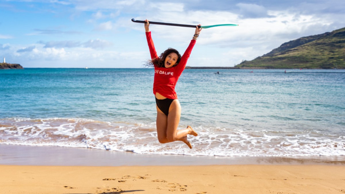 a woman throwing a frisbee at the beach