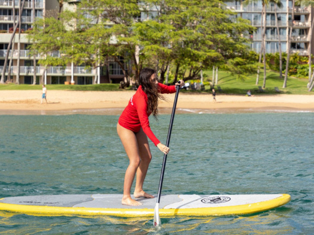 a young girl riding a wave on a surfboard in the water