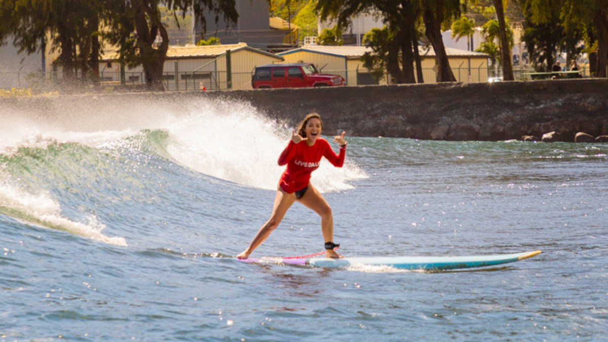 a young girl riding a wave on a surfboard in the water