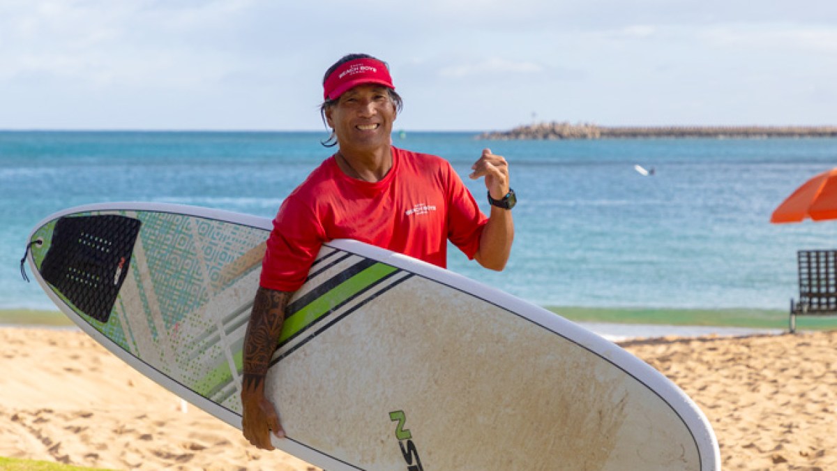 a man carrying a surf board on a body of water