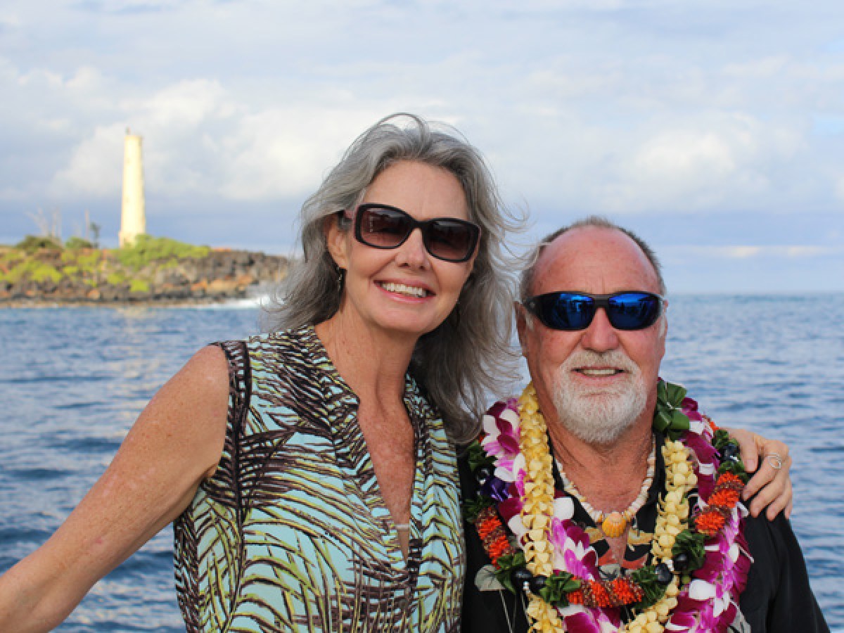 a man and a woman standing next to a body of water