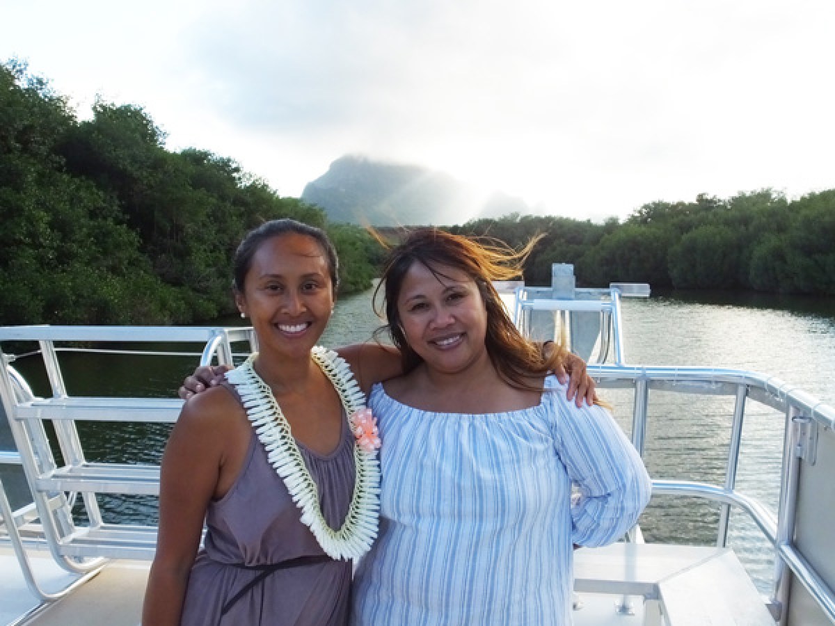 a woman standing in front of a body of water posing for the camera